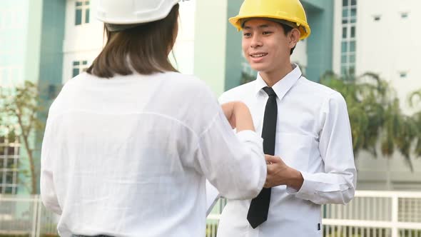 Asian businessman talking with Asian business women building construction project alt