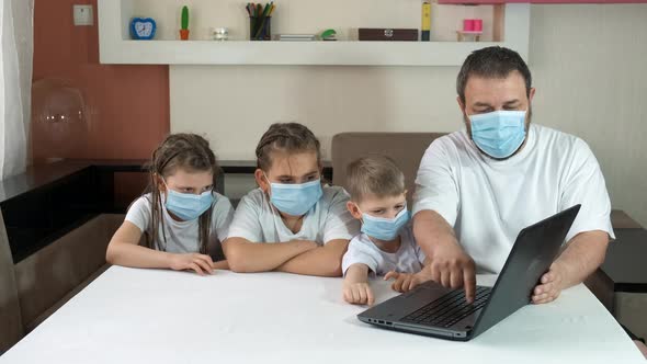 Dad Teaches Children How to Use a Laptop Indoors