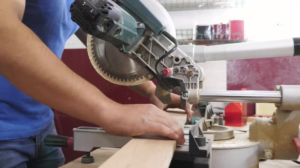 Carpenter cutting wood with a circular saw alt