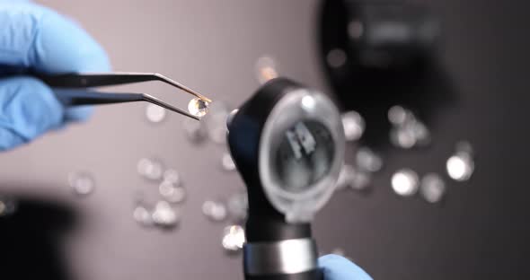 Gloved Jeweler Holds Tweezers with Gem and Examines Through Magnifying Glass Slow Motion  Movie alt