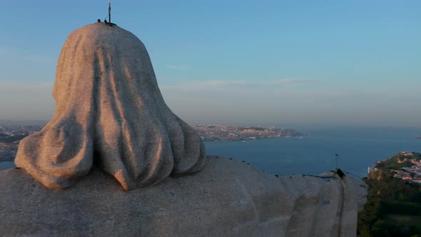 Close Up Back Aerial View of Sanctuary of Christ the King Statue on the Hill with Reveal of Urban alt