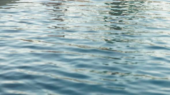 Cute Girl Sitting with Feet in Swimming Pool