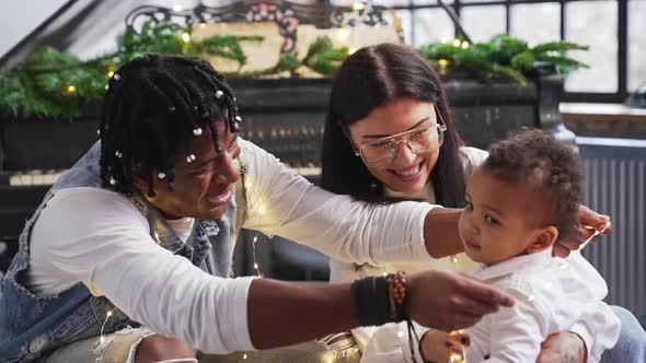 Adorable Baby Spending His First Christmas with Loving Multiracial Parents alt