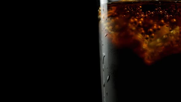 Glass With Whiskey And Soda With Ice Cubes And Bubbles On A Black Background