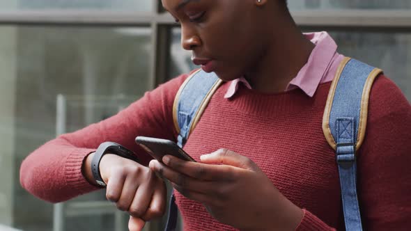 African american using her smartphone in street alt