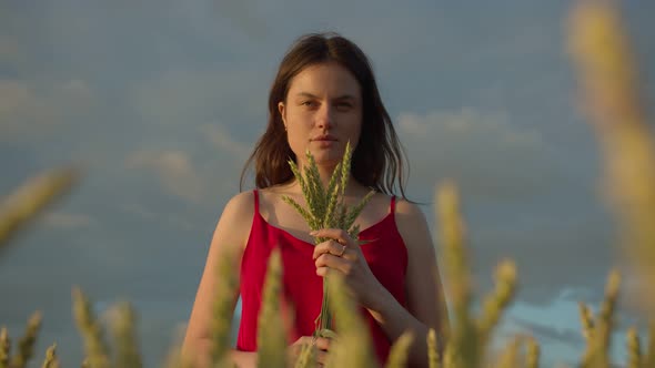 Girl in a Red Dress with a Bouquet of Rye Stalks
