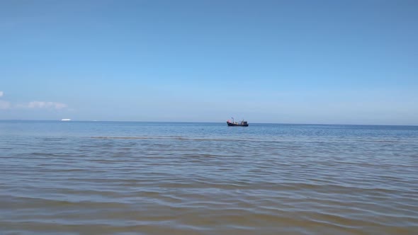 Small fishing boats float on the horizon
