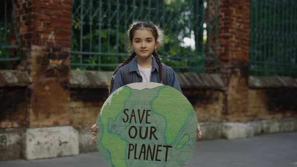 Little School Girl Demonstrating Banner with Inscription Massage Text Save the Planet Outdoor alt