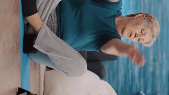 Vertical Video Senior Woman Watching Training Lesson on Tablet to Exercise alt