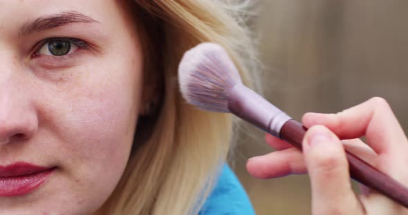 blonde young girl half face, make up powder cheeks organic rice powder, natural cosmetics alt