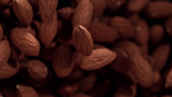 Super Slow Motion Shot of Almonds Flies After Being Exploded Against Black Background 1000Fps alt