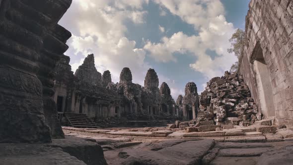 Timelapse of Temple at Angkor Wat Complex with Blue Skies, Clouds and Piles of Rocks alt