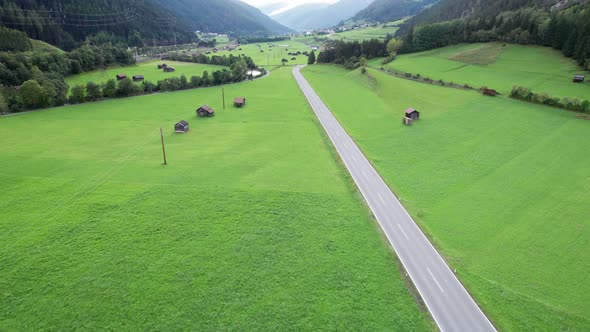 Empty Road in Austrian Valley Between Green Fields in the Alps Aerial View alt