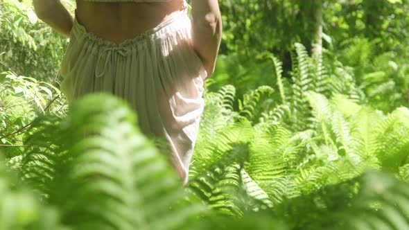 Sexy Woman Walking in Nature Between Ferns In Forest alt