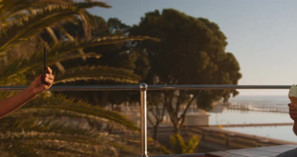 Mother and son eating ice cream and using phone alt