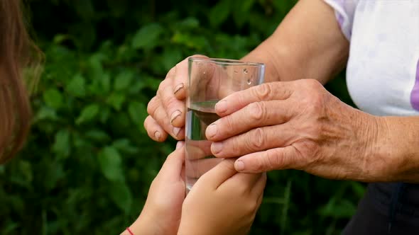 The Child Gives a Glass of Water to the Grandmother alt