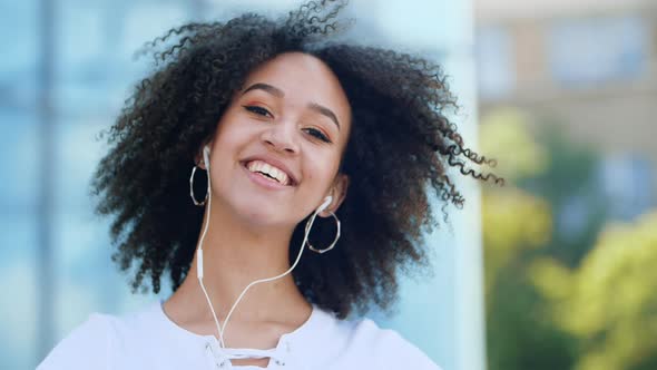 Happy Joyful Young Afro American Millennial Woman Enjoys Jumping High Waving Arms and Dancing in Air alt