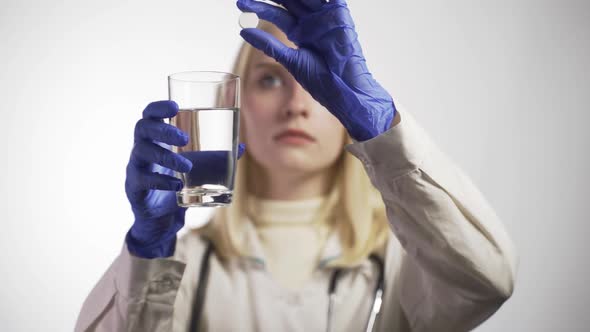 The Doctor Drops the Effervescent Tablet Into the Glass and Dissolves It alt