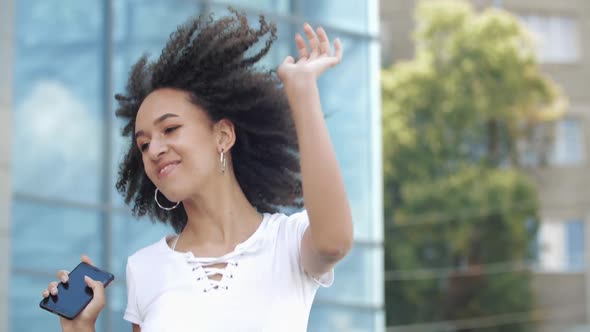 Happy Joyful Young Afro American Millennial Woman Enjoys Jumping High, Waving Arms and Dancing in alt