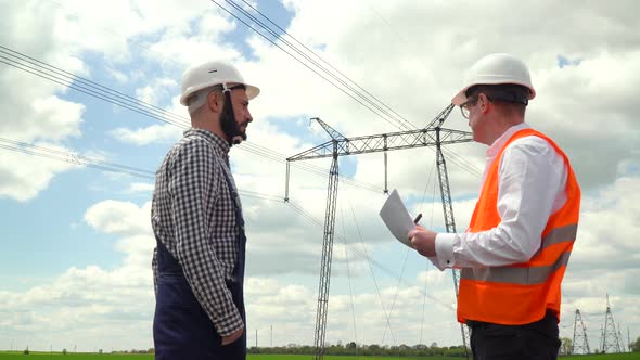 Two Engineers Working Near Transmission Lines alt