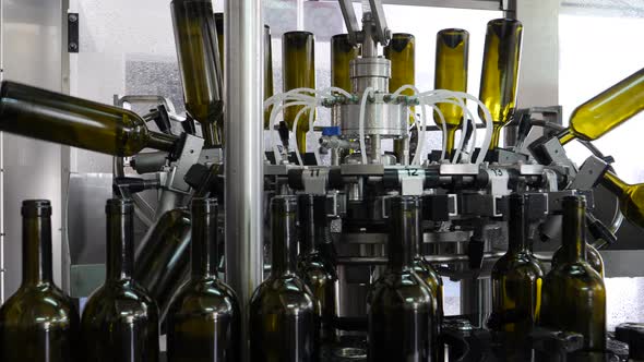 Wine bottles are sanitized in industrial machines at the wine bottling factory alt