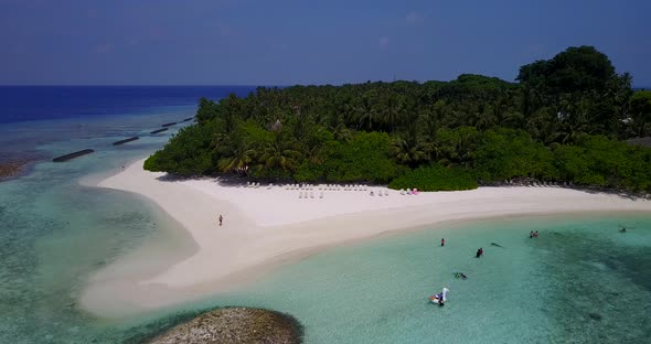 Beautiful flying abstract view of a sandy white paradise beach and aqua blue ocean background in hig alt