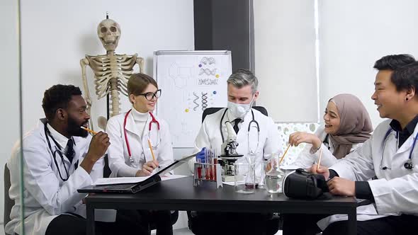 Male and Female Future Medical Workers Carefully Listening the Respected Bearded Doctor-Mentor alt