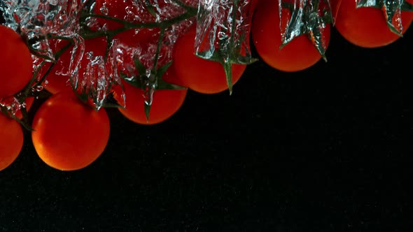 Super Slow Motion Shot of Falling Cherry Tomatoes Into Water at 1000Fps. alt