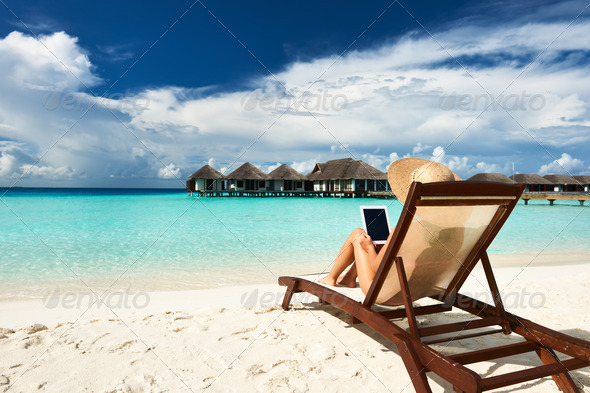 Young woman with tablet pc at the beach - Stock Photo - Images