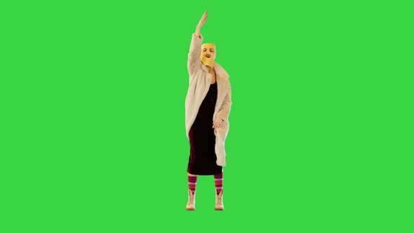 Young Girl in Balaclava Making Some Energetic Hand Gestures Shouting on a Green Screen Chroma Key