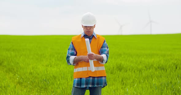 Male Engineer Working While Holding Blueprint alt