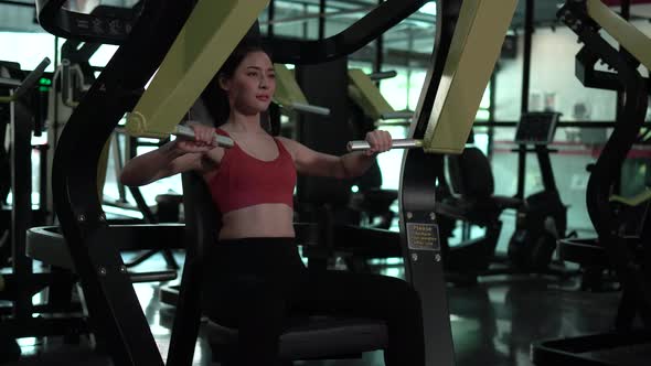 Beautiful woman in fitness center, Young woman working out in the Gym with fitness machine