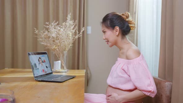 Asian young pregnant woman talking virtual online with medical doctor. alt