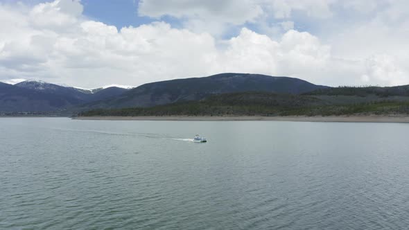 Aerial Flyby Shot of a Lone Party Boat on a Beautiful Mountain Lake in Colorado (Dillon Reservoir) alt