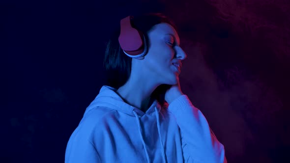 Portrait of Charming Young Woman Enjoying Music From Smartphone in Big Red Headphones. Close Up alt
