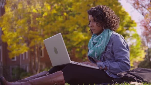 College student on campus in fall using laptop computer