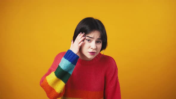 Young Cute Woman in Red Sweater with Rainbow Sleeves Looking at Camera with Question and Showing alt