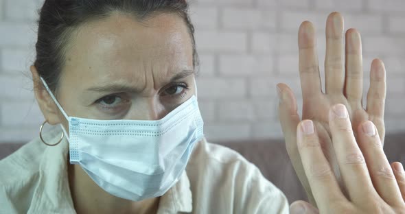 Woman in medical mask by window.  alt