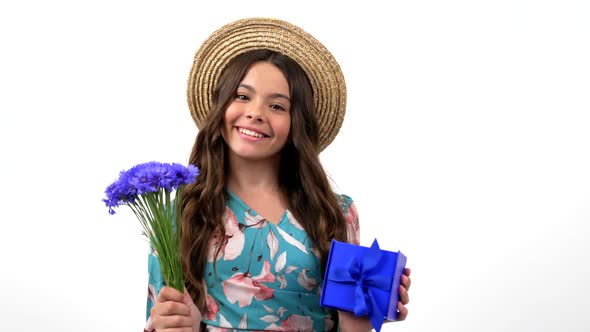 Smiling Kid in Summer Straw Hat Hold Wildflower Flower Bouquet Centaurea and Gift Box Boxing Day