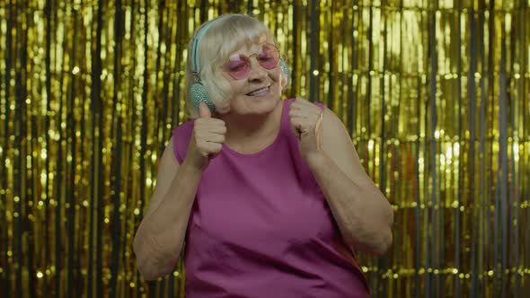 Senior Old Woman Dances, Listens Music on Headphones. Relaxing, Enjoying, Having Fun, Smiling alt