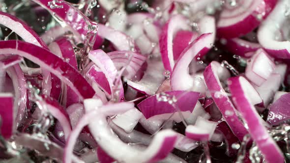 Super Slow Motion Shot of Falling Red Onion Cuts Into Oil in Pan at 1000 Fps. alt