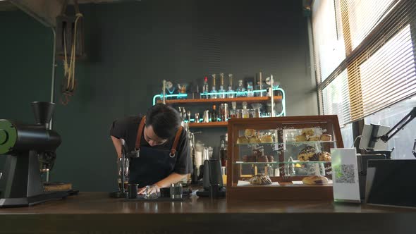 4K Asian man barista making hot espresso shot from flair espresso coffee maker alt