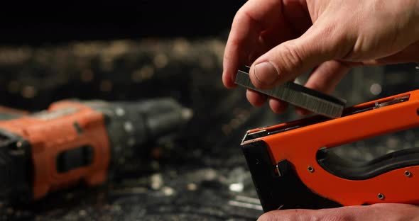 Male hand use stapler, insert staples in workshop