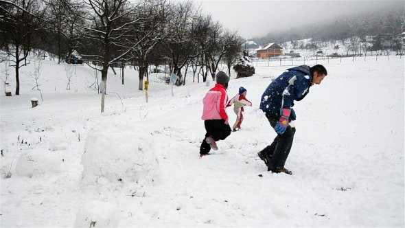 Father And His Kids Playing With Snow 01