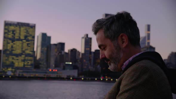 Man in New York City taking photos of city with cell phone