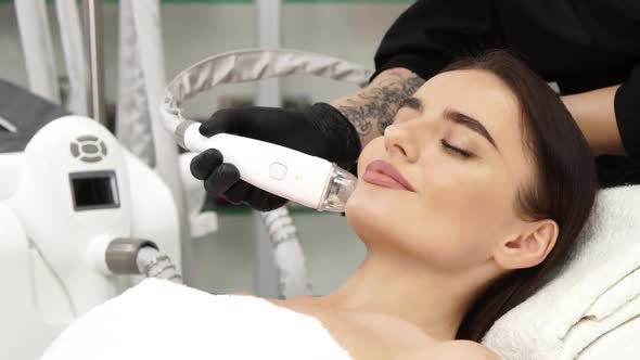 Lovely Woman Lying at Space and Receiving Body Shape Procedures for Her Face alt