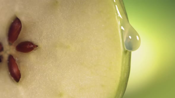 Drop of Water Flows Down the Surface of a Ripe Juicy Green Apple Slice alt