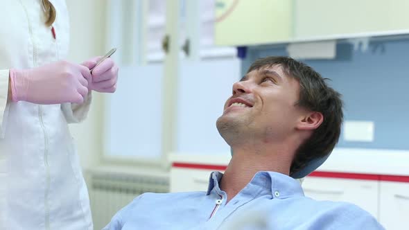 Close up of attractive man having dental examination of aching tooth alt