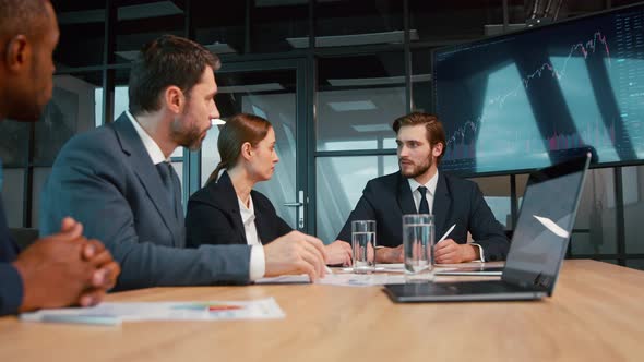 Corporate manager showing development graph using tv technology alt