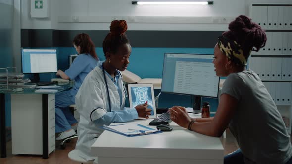 African American Patient and Doctor Looking at Radiography alt